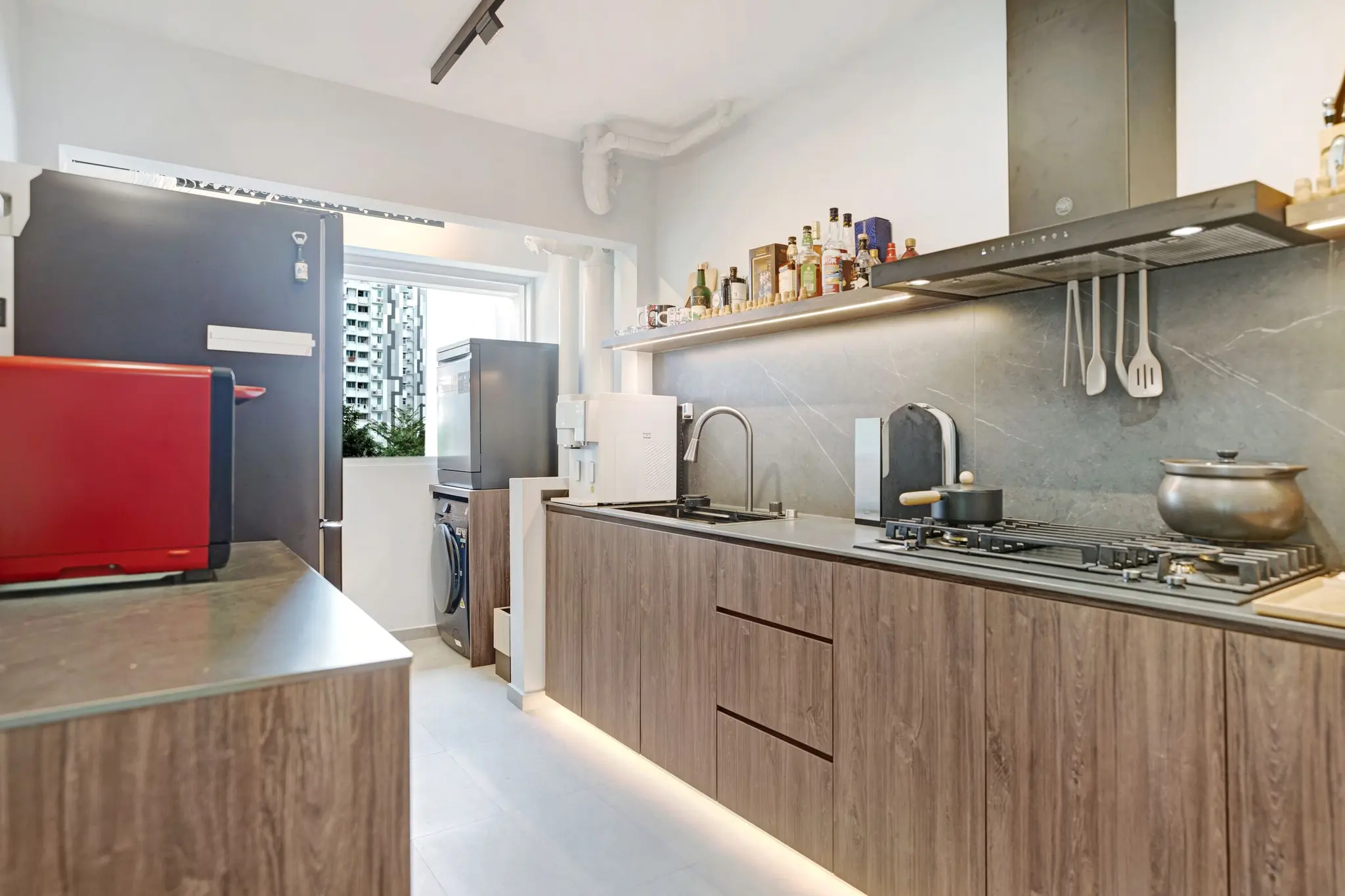 Warm wood kitchen with dark stone surfaces at 213C Punggol Walk