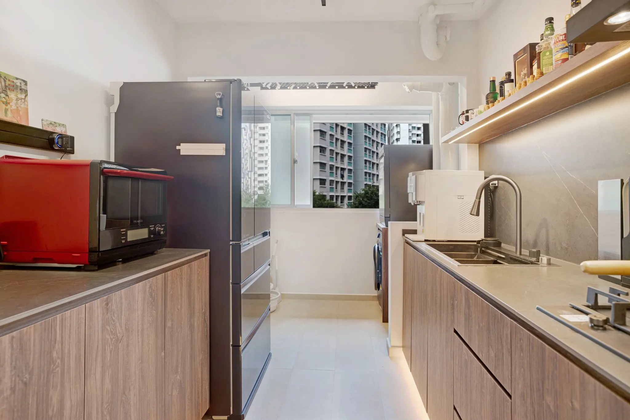 Warm wood kitchen with dark stone surfaces at 213C Punggol Walk