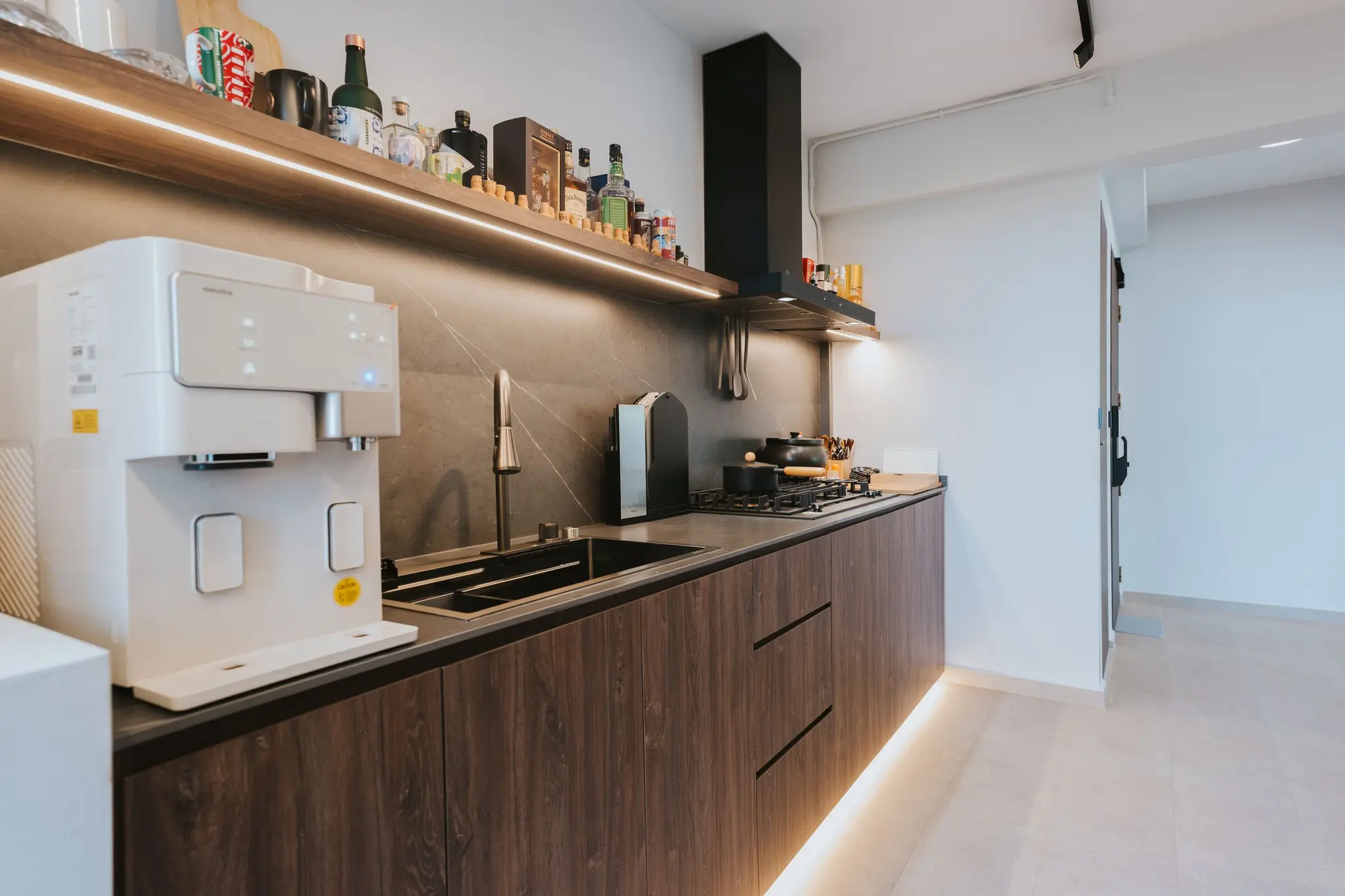 Warm wood kitchen with dark stone surfaces at 213C Punggol Walk
