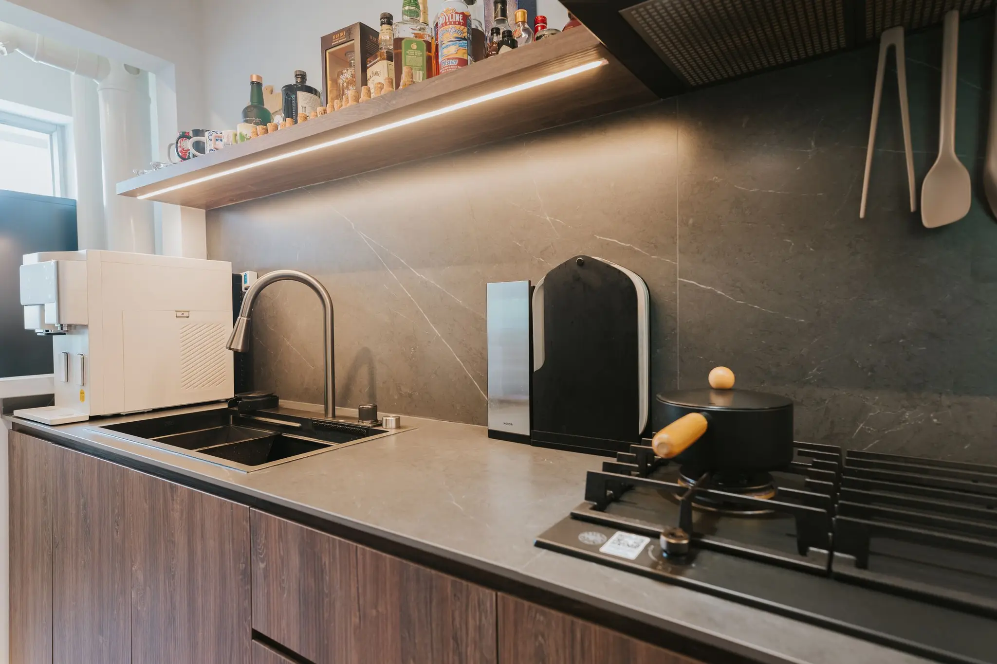Warm wood kitchen with dark stone surfaces at 213C Punggol Walk