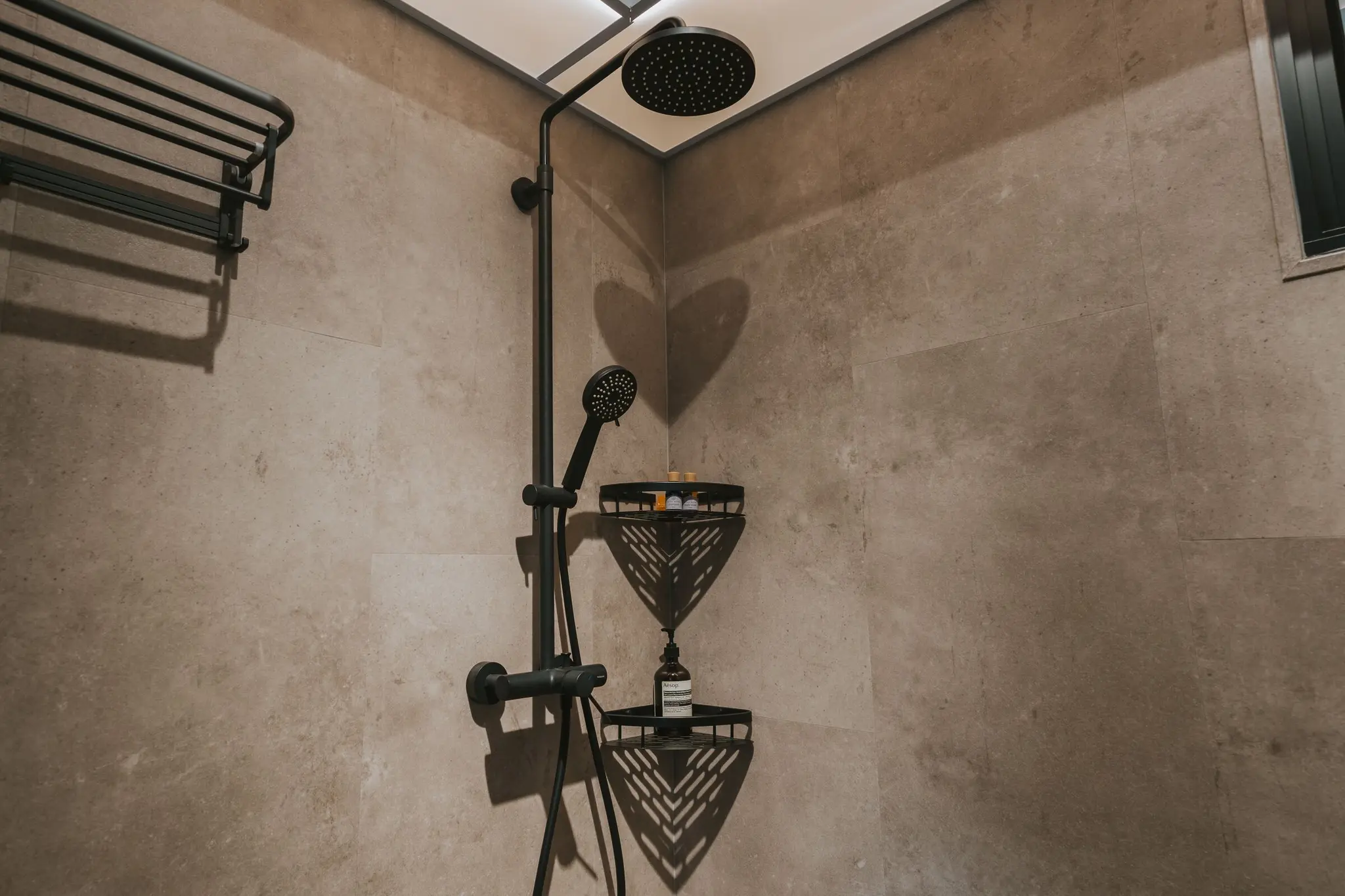 Stone-look bathroom with a round mirror at 213C Punggol Walk