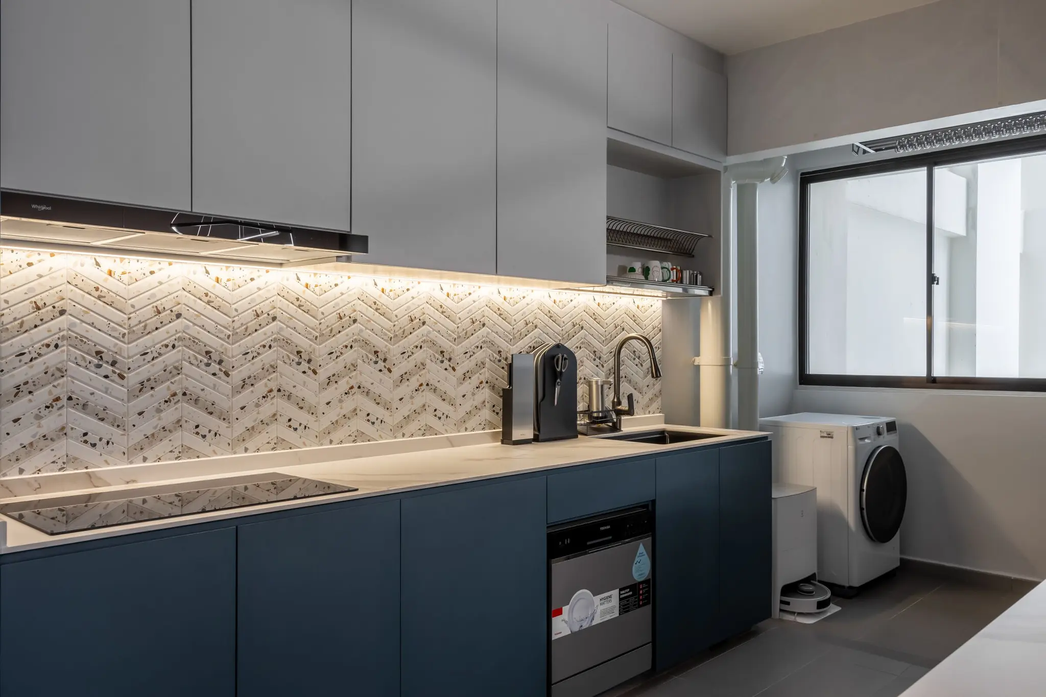 Blue kitchen cabinetry and terrazzo backsplash at 447A Punggol Way