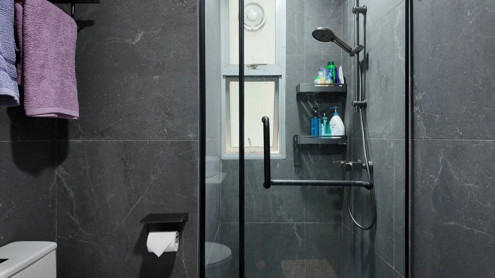 Dark-tiled bathroom shower at Lakeshore